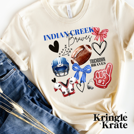 A cream-colored short-sleeve t-shirt featuring a vibrant, collage-style design that celebrates the Indian Creek Braves. The design includes football-themed graphics such as a helmet, shoulder pads, football, foam finger labeled "#1," a whistle, and a football play diagram. Additional playful elements like black hearts and red and blue bows add to the spirit of the design. The text "Indian Creek Braves" is printed in bold and cursive fonts, with "Touchdown Braves" also featured in the design. 