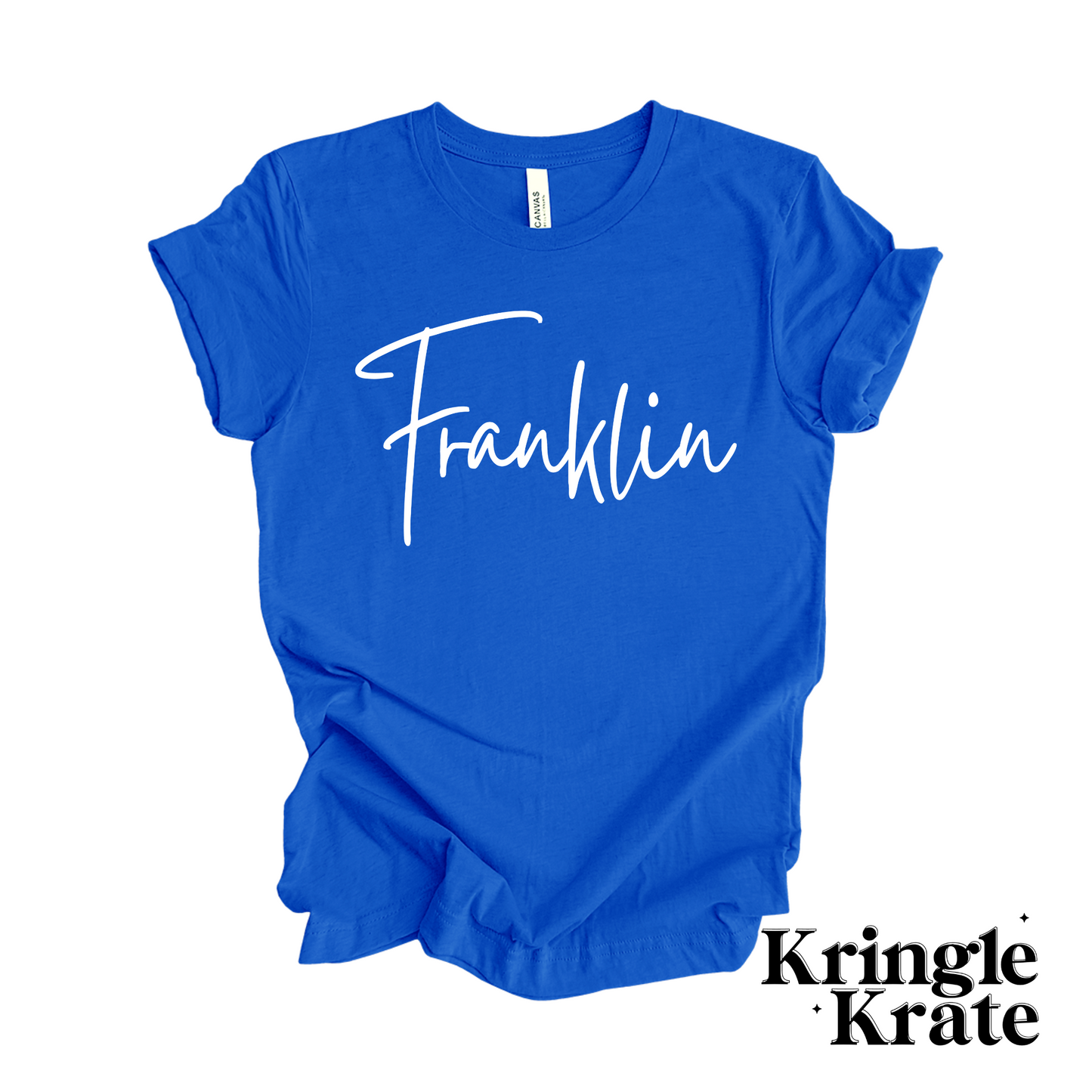 A royal blue short-sleeve t-shirt featuring a white puff print handwritten text design reading "Franklin" in a script font. The shirt is displayed as if it were laying flat on a the floor.